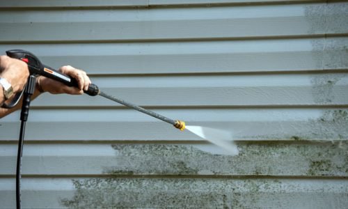 An,Unidentified,Man,Uses,A,Power,Washer,To,Clean,Mold